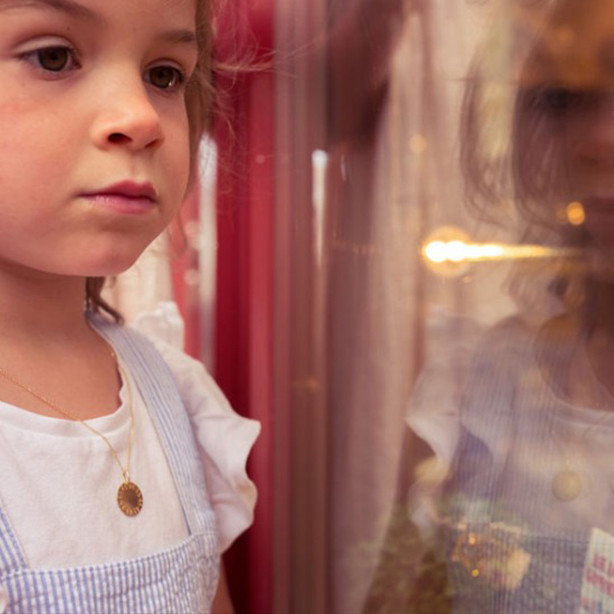 Baptismal medal in 18k yellow gold, worn by a child.